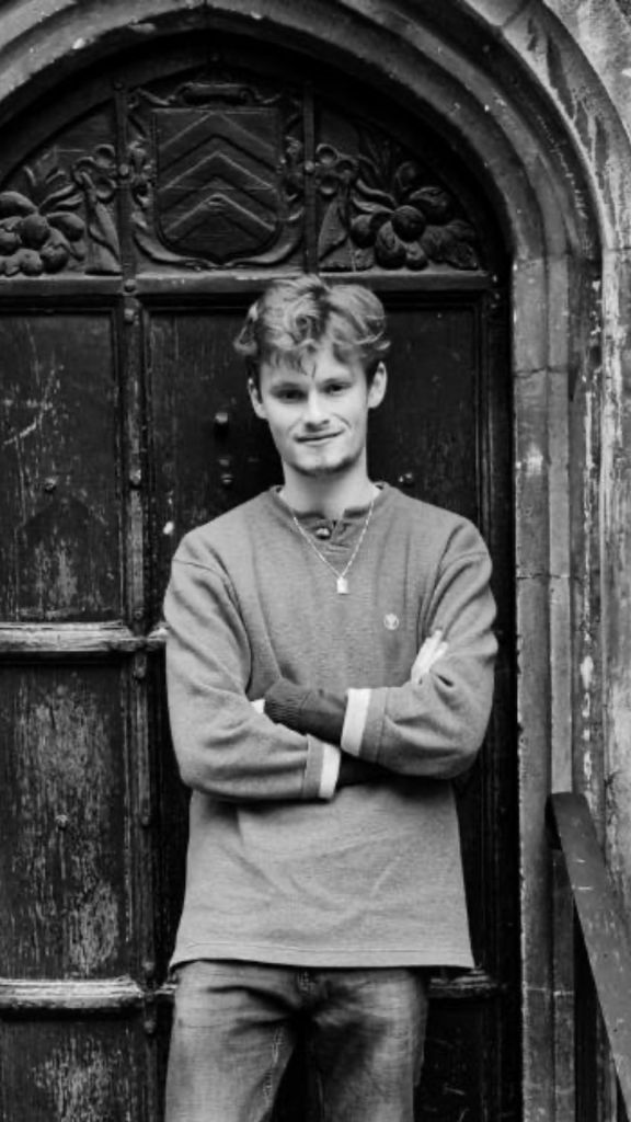 Young white male standing casually in church doorway with arms crossed musician from the Broadstone Music Series